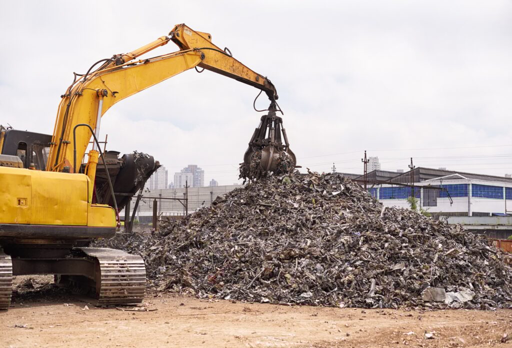 Cropped shot of an excavator sorting through a pile of scrap metal